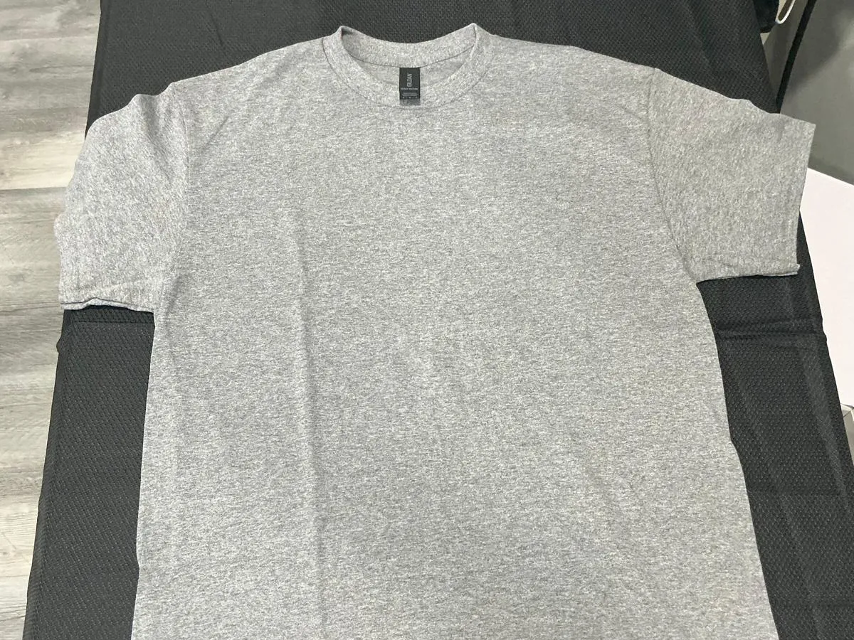 A heather gray Gildan crew-neck t-shirt laid flat and unprinted on the black pad of a heat press
