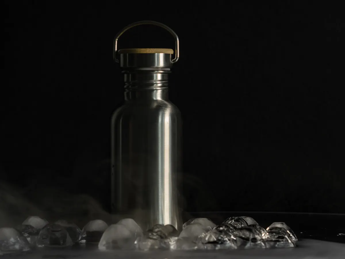 A plain stainless steel insulated drink bottle with a bamboo-topped lid, with no branding on it