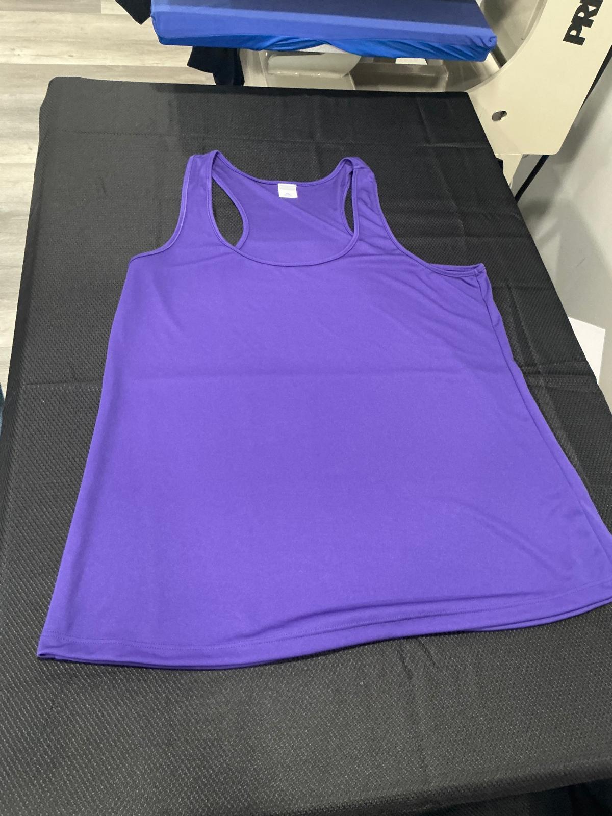 A plain purple women's racerback tank top laid flat and unprinted on the black pad of the heat press